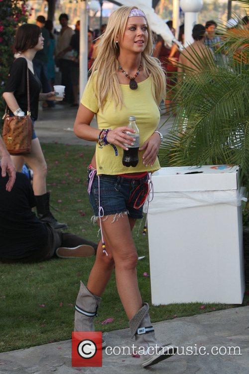 Tara Reid wearing a yellow t-shirt with no bra enjoying a refreshing drink with