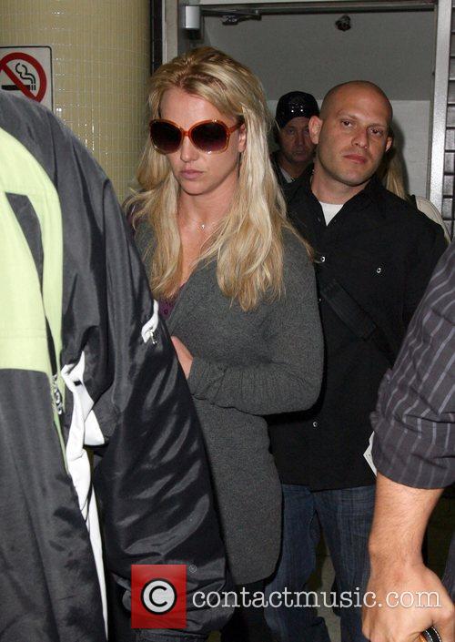Britney Spears is surrounded by paparazzi as she arrives 
at LAX to catch a
