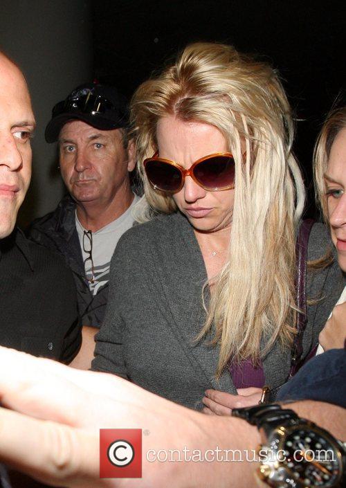 Britney Spears is surrounded by paparazzi as she arrives 
at LAX to catch a
