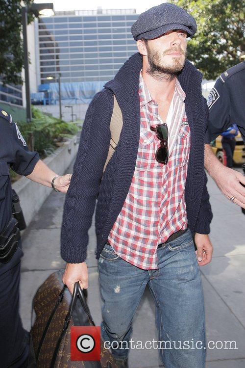 David Beckham - David Beckham, carrying his Louis Vuitton travel bag, gets a police escort as he ...
