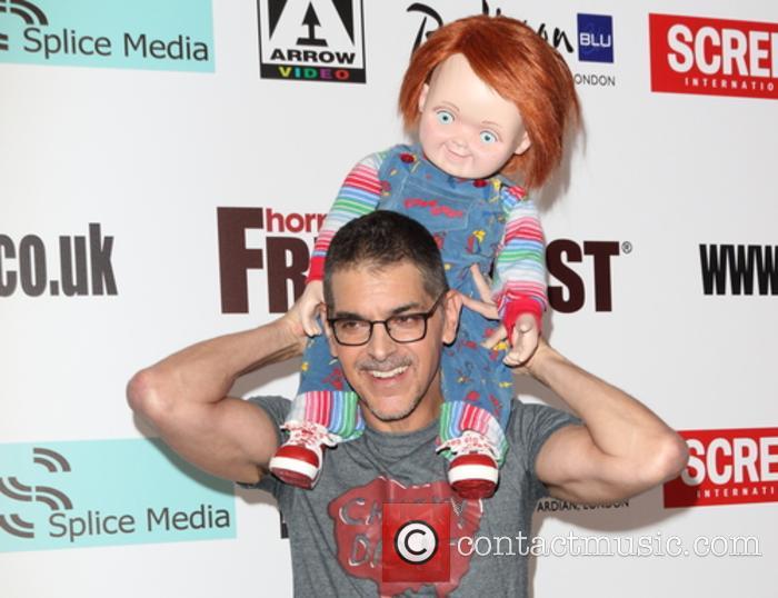 Don Mancini poses with the creepy Chucky doll