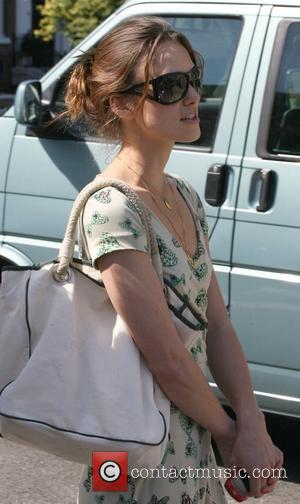 Keira Knightley tries to avoid photographers by hiding behind dark shades 