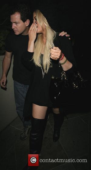 Lindsay Lohan leaves home for a night out wearing knee length leather boots and a short