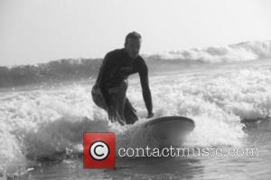 Victoria Beckham posted this picture of David Beckham with the caption 'Brooklyn took this pic of David while teaching him to surf!!!! X VB'