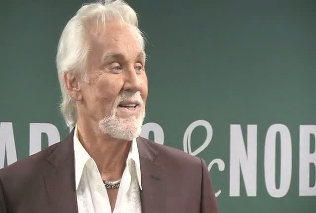 Kenny Rogers Seems Mildly Taken Aback By Photographers At Book Promotion