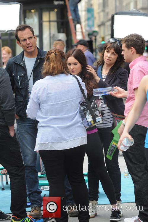 Will Arnett stands with Megan Fox as she is preened on the set