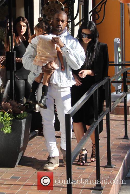 Kim Kardashian and Kanye West carry their daughter North West