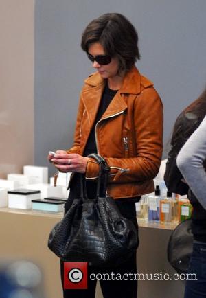 Katie Holmes checking her Blackberry while shopping at The Corner at Gendarmenmarkt. She bought the brown leather jacket she's wearing...