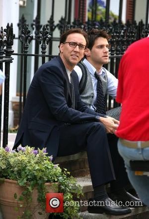 Nicolas Cage reading a book on set whilst on a break from filming on location in Primrose Hill for his...