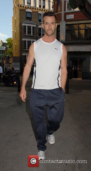 Rupert Everett sporting track suit bottoms and athletes top walking in Covent Garden London, England - 18.07.07