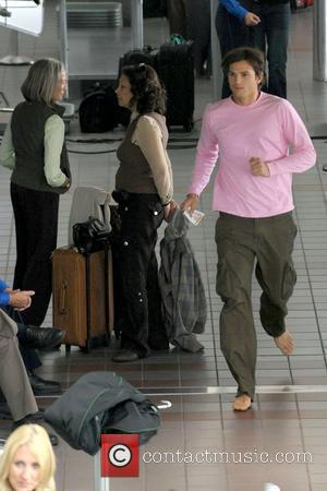 Ashton Kutcher running barefoot on the set of his new film 'Valentine's Day' shooting on location at LAX Los Angeles,...