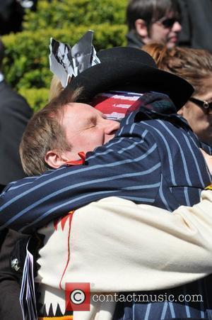 Adam Ant aka Stuart Goddard hugs a fellow mourner outside the Holy Trinity Church in Marylebone after a funeral service...