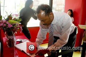 A fan showing their respect by signing the memorial book Madame Tussauds in Washington, D.C. installs a Michael Jackson tribute...