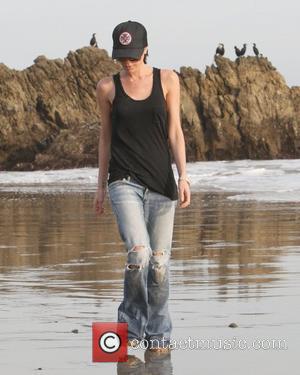 Victoria Beckham  gets her feet and jeans wet in the water on the beach Malibu, USA - 31.01.10