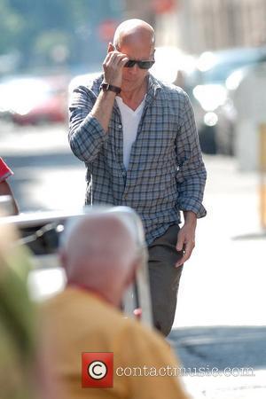 Bruce Willis puts on his sunglasses as he arrives on the film set for 'A Good Day to Die Hard'...