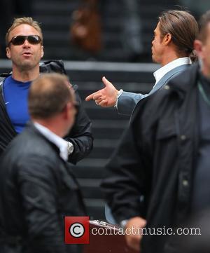 Brad Pitt  on location of his new movie 'The Counselor' gesturing a gun sign with his hand before he...