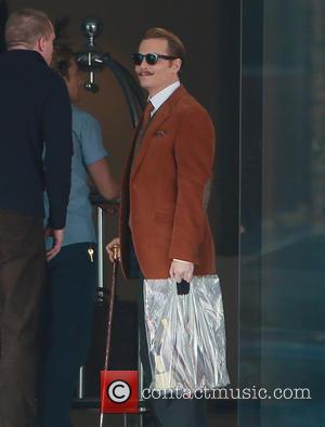 Johnny Depp - Johnny Depp filming on the set of 'Mustache' carrying a gold top cane and sporting a curly...