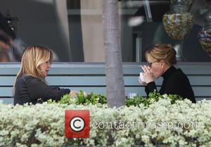 Melanie Griffith - Melanie Griffith smoking a cigarette at the table while out for lunch with a friend in West...