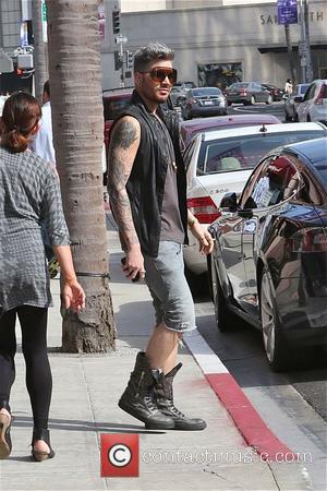 Adam Lambert - Singer Adam Lambert looks fashionable in knee length denim shorts, boots and sleeveless black leather waist jacket...