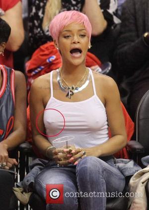 Rihanna - Rihanna's nipple ring can be seen beneath her vest at the Los Angeles Clippers NBA basketball game against...