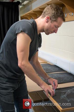 Chris Martin - Chris Martin signs the original etching of the Coldplay single, Midnight by Mila Fürstová at the Royal...
