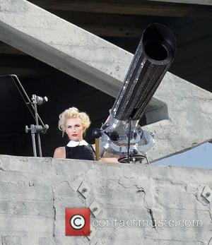 Gwen Stefani - Gwen Stefani mans an giant cannon atop a high rise building in downtown LA while filming a...