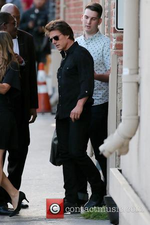 Tom Cruise stops to sign pictures for fans before entering ABC studios for an episode of Jimmy Kimmel Live! -...