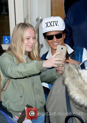 Bruno Mars signs memorabilia for fans outside Maida Vale after performing on the Radio One live lounge. - London, United...