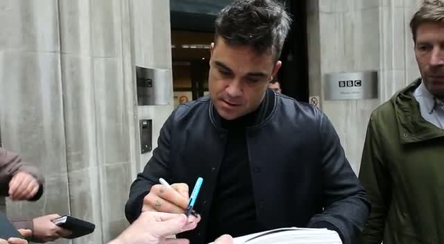 Robbie Williams Rushes Some Autographs As He Leaves Radio 2 Rehearsals